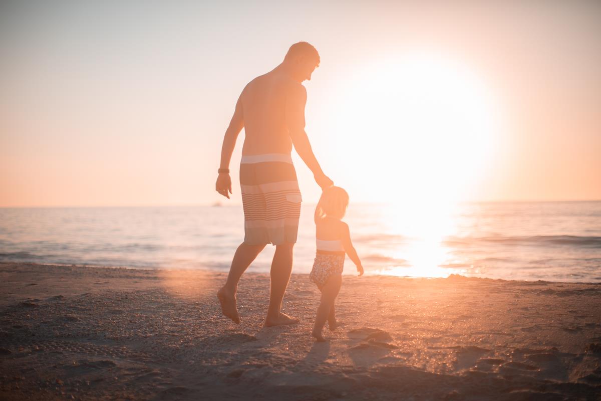 pai andando com filho na praia nos dias de visitação